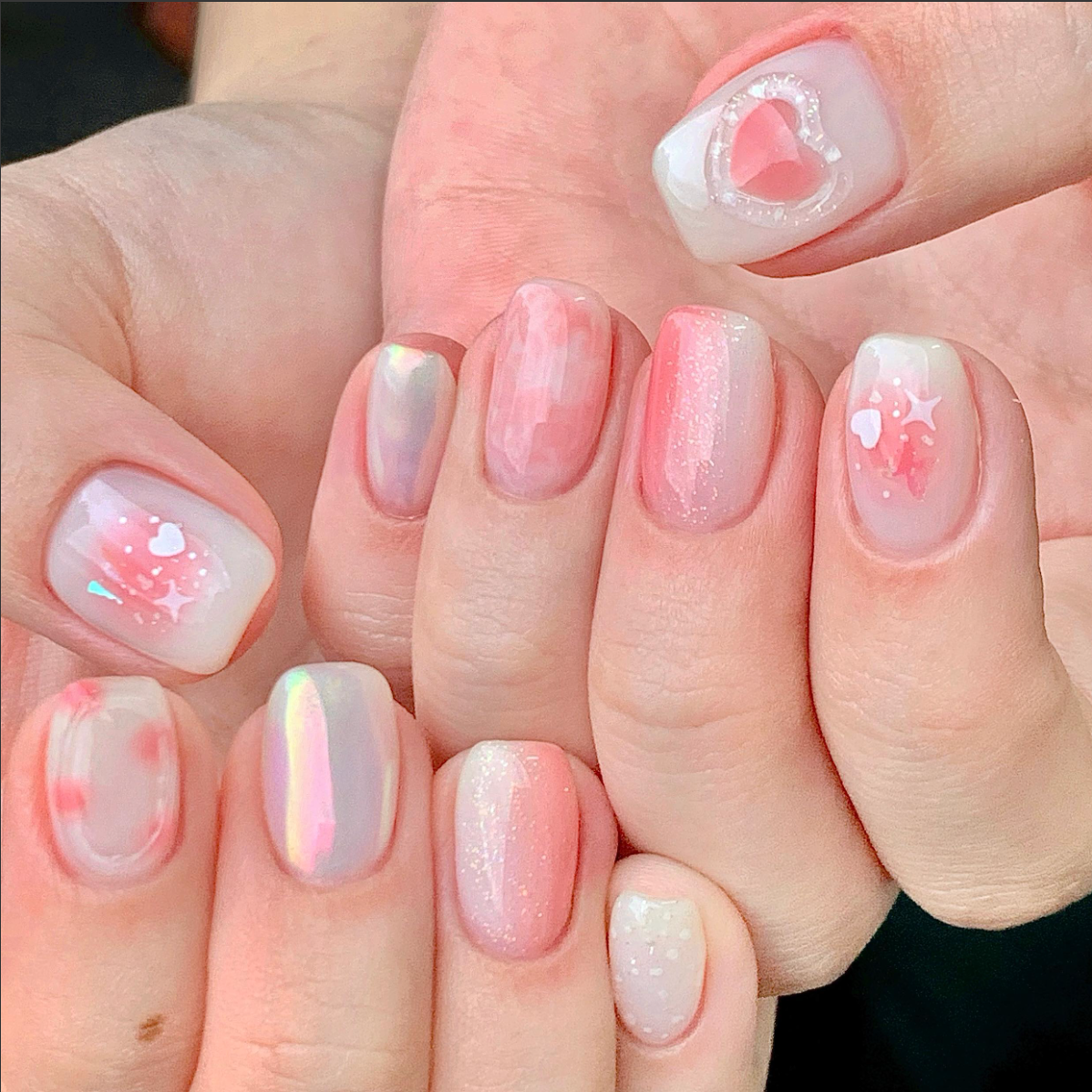 Soft pink jelly nails with hearts and stars.